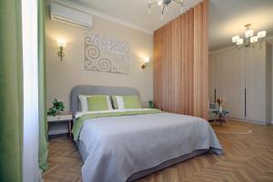 a bedroom with a large bed with green pillows at Central Light Apartment in Almaty