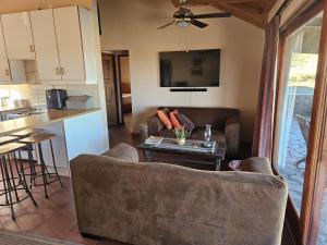 a living room and kitchen with a couch and a table at Skoorsteenberg Farm Camping & Accommodation in Tankwa Karoo