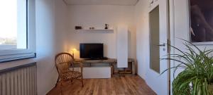 a room with a desk with a television and a chair at Helle Ferienwohnung mit Garten und Terrasse, direkt am Waldrand gelegen in Herzogenrath