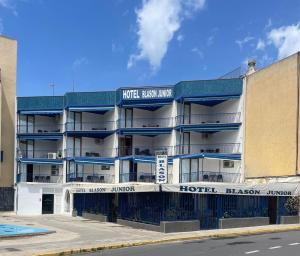 un edificio de apartamentos con balcones azules en una calle en Hotel Blason Junior, en Peñíscola