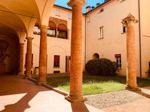 eine Gruppe von Säulen im Innenhof eines Gebäudes in der Unterkunft TL Palazzo Fantuzzi in Bologna