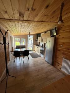 a kitchen with a refrigerator and a table and chairs at Agrochalupki in Korczowe