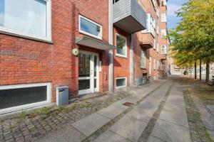 an empty street in front of a brick building at Hyggelig klassisk Aalborg-lejlighed in Aalborg