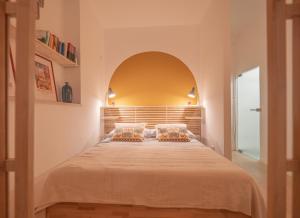 a bedroom with a large bed with an arch above it at La Casa di Nina e la Luna in Perugia