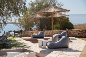un patio con sofás, una sombrilla y una mesa en Villa Aristoteles, en Halki