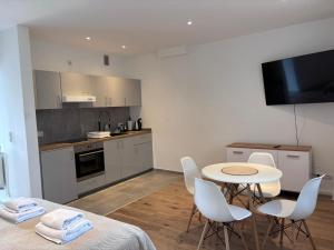 a kitchen with a table and chairs and a kitchen with a tv at Pensjonat Eden Apartament 8 in Borne Sulinowo