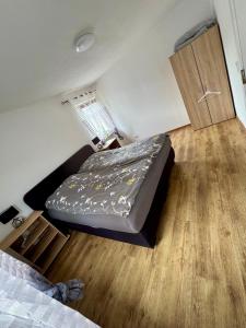 a small bedroom with a bed and a wooden floor at Ataman in Hessisch Oldendorf +1 photo