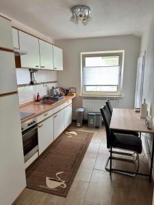 a kitchen with white cabinets and a table with chairs at Ataman in Hessisch Oldendorf