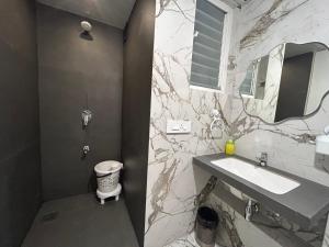 un baño con lavabo y espejo en UHomes Pune airport, en Pune