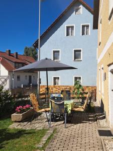 Un patio con una mesa y sillas y una sombrilla. en Gästehaus Ulrike, en Steinberg 11 fotos más