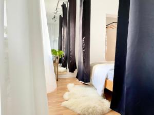 a bedroom with white curtains and a white rug at Cosy Sunset Flat - Kongress Palais & Herkules View in Kassel