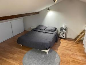 a bedroom with a bed with a black comforter at La petite chapelle in Roche-la-Molière +7 photos