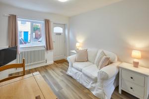 a living room with a white couch and a tv at 94 Roseberry Cottage in the market town of Guisborough in Guisborough