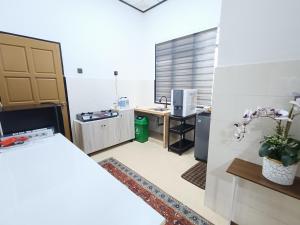 a room with a kitchen with a desk and a counter at Homestay Teratak Adamia in Dungun