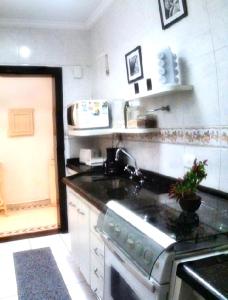 een keuken met een spoelbak en een fornuis bovenste oven bij Janela para o oceano in São Vicente