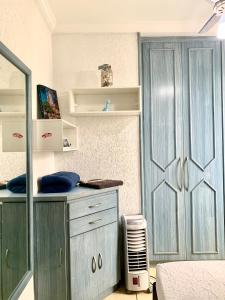 een slaapkamer met een blauwe kast en een ventilator bij Janela para o oceano in São Vicente