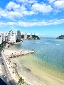 een uitzicht op een strand met gebouwen en de oceaan bij Janela para o oceano in São Vicente