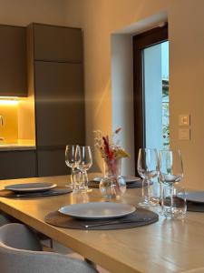 Una mesa de madera con copas de vino y platos encima. en Villa Arancio, en Paestum