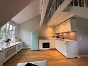 a kitchen with white cabinets and a blue refrigerator at NEU Keitum - Moderne Gemütlichkeit unter Reet in Sylt