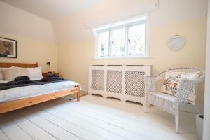 a bedroom with a bed and a window and a crib at Lavender Cottage in Burley