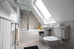 a bathroom with a toilet and a shower and a sink at Lavender Cottage in Burley +57 photos