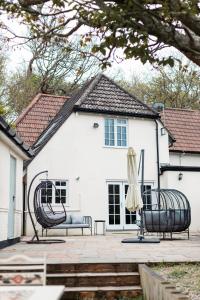 a white house with two chairs and an umbrella at Lavender Cottage in Burley