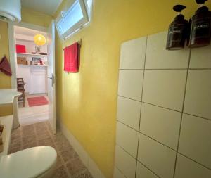 een badkamer met een gele muur met een wastafel en een raam bij Casa Albaicin 1 in Granada +19 foto's