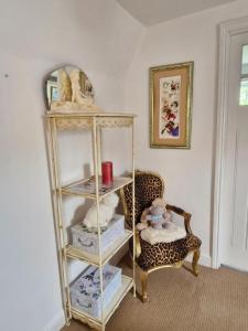 a room with a shelf with stuffed animals and a chair at Cosy cottage at rustic escapes  +44 photos