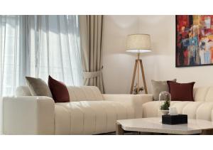 a living room with two white couches and a table at Yas Island 2BR - Spacious Apartment with Balcony in Abu Dhabi