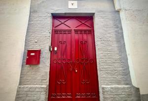 een rode deur in een bakstenen gebouw met een brievenbus bij Casa Albaicin 1 in Granada