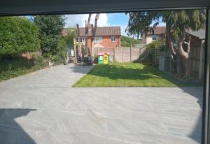 a driveway in front of a house with a yard at Cosy Studio Flat-Just Renovated-Free Street Parking & Independent Entrance in Hanworth