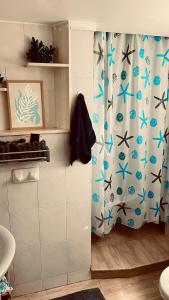 a bathroom with a shower curtain with blue spiders on it at Nereid Bungalow in Fánai