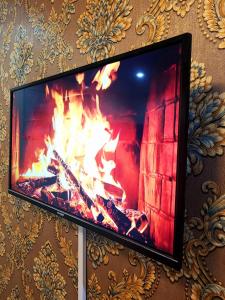 a flat screen tv hanging on a wall with a fireplace at Mini Studio Calme Propre et Discrète in Dakar