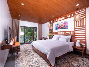 a bedroom with a large bed with a wooden ceiling at Adumi Retreat Tam Cốc in Vũ Lâm