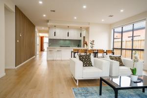 a living room with white chairs and a table at Charming Deanside Home with Cosy Vibes in Caroline Springs
