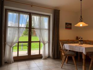 a dining room with a table and a large window at Ferienwohnung Alpina 2 in Wallgau