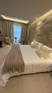 una camera da letto con un grande letto bianco in una stanza di Alcántara Hotel Chacras de Coria a Ciudad Lujan de Cuyo Altre 12 foto