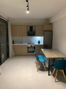 スパルティアにあるProfil villasのキッチン(木製テーブル、青い椅子付)