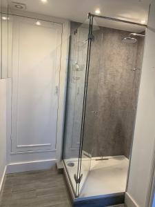 a shower with a glass door in a bathroom at The Annexe Westbury House in Great Dunmow