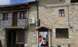 an old stone building with a pepsi machine in front of it at Valderejo Etxea in Lalastra