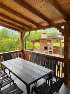 a wooden table and chairs on a deck at Casa Edy in Vişeu de Sus