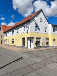 a yellow and white building on the side of a street at Ferienwohnungen Paul und Dorothea in Döllstädt