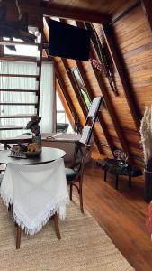 een zolderkamer met een bureau, een tafel en een stoel bij Chalé nascer do sol in Massaranduba