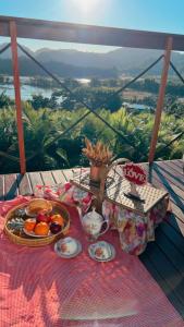 een tafel met een dienblad met eten op een tafel bij Chalé nascer do sol in Massaranduba