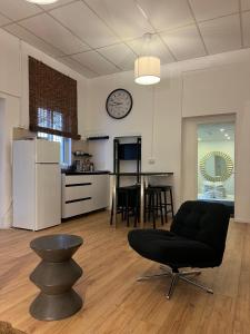 a living room with a chair and a clock on the wall at Stylish Garden Apt 2 Min Beach in Tel Aviv