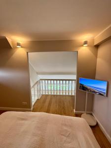 a bedroom with a bed and a flat screen tv at NEU Keitum - Moderne Gemütlichkeit unter Reet in Sylt +5 photos