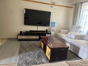 Una sala de estar con un televisor de pantalla plana grande. en Jrungaru BnB, en Nanyuki