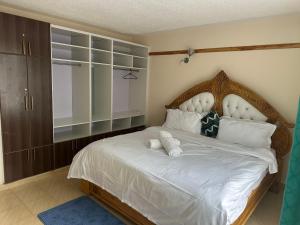 Un dormitorio con una cama grande con cabecero de madera. en Jrungaru BnB, en Nanyuki 6 fotos más