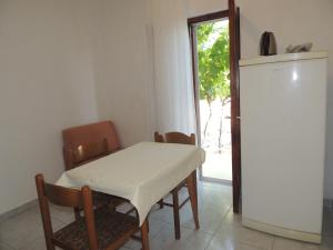 a dining room with a table and chairs and a window at CROSurf Apartments Pelješac Kučište in Kučište