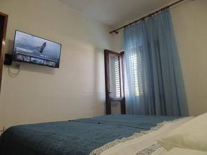 a bedroom with a bed and a tv on the wall at CROSurf Apartments Pelješac Kučište in Kučište